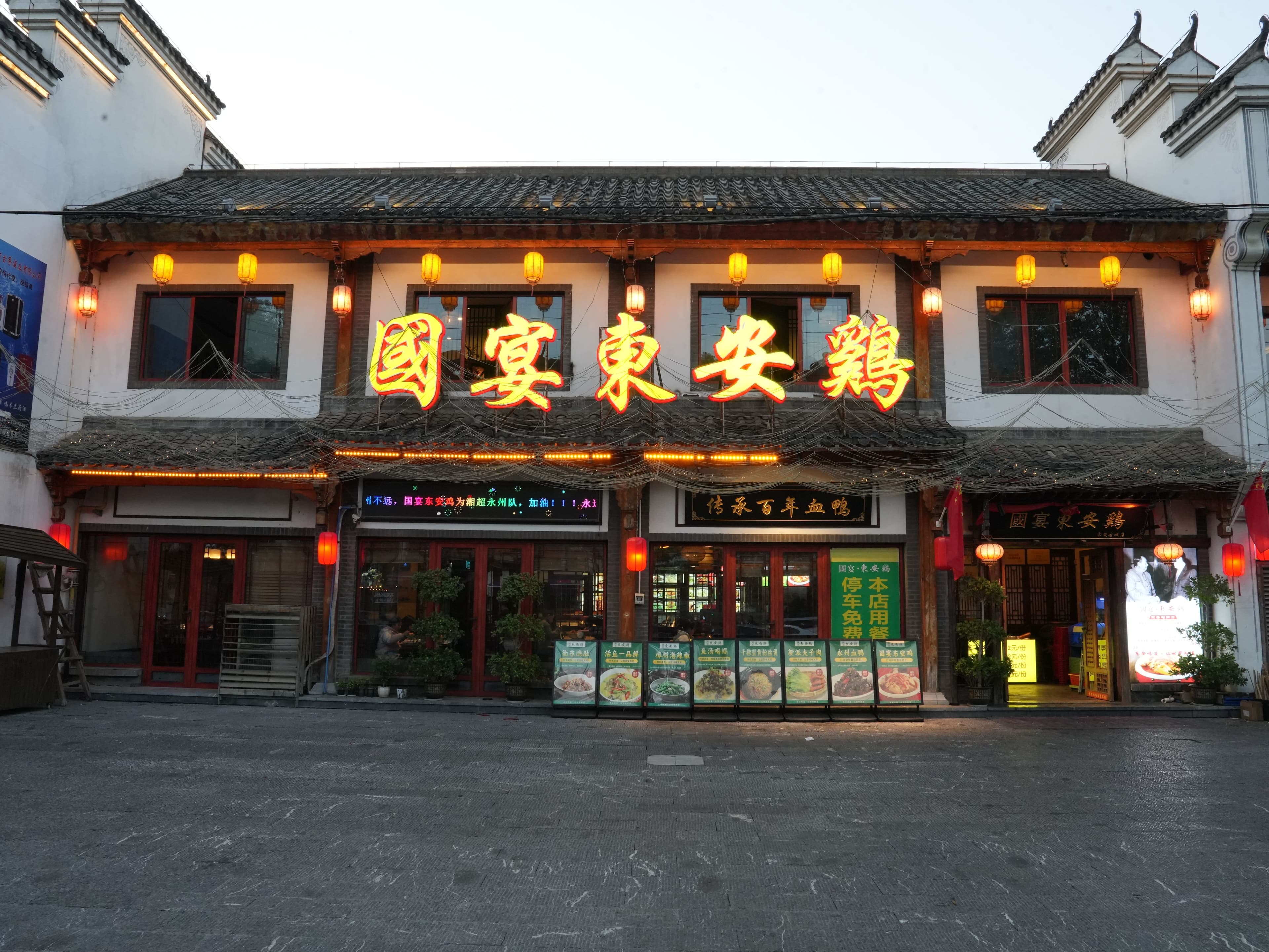 Restaurant storefront lit with red lanterns at dusk